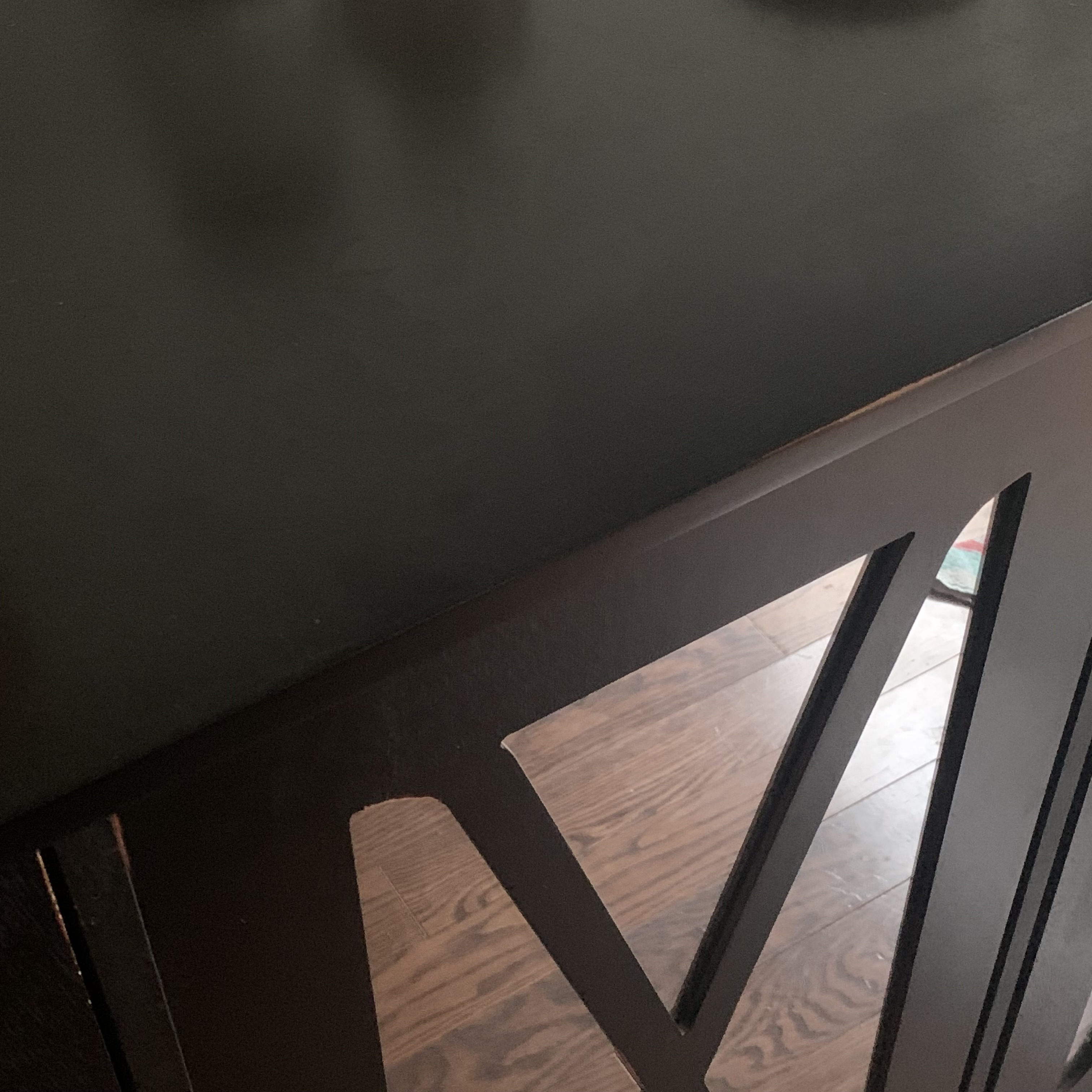 The material present in the photo is Wood that has been painted black located next to my kitchen/dinner table.