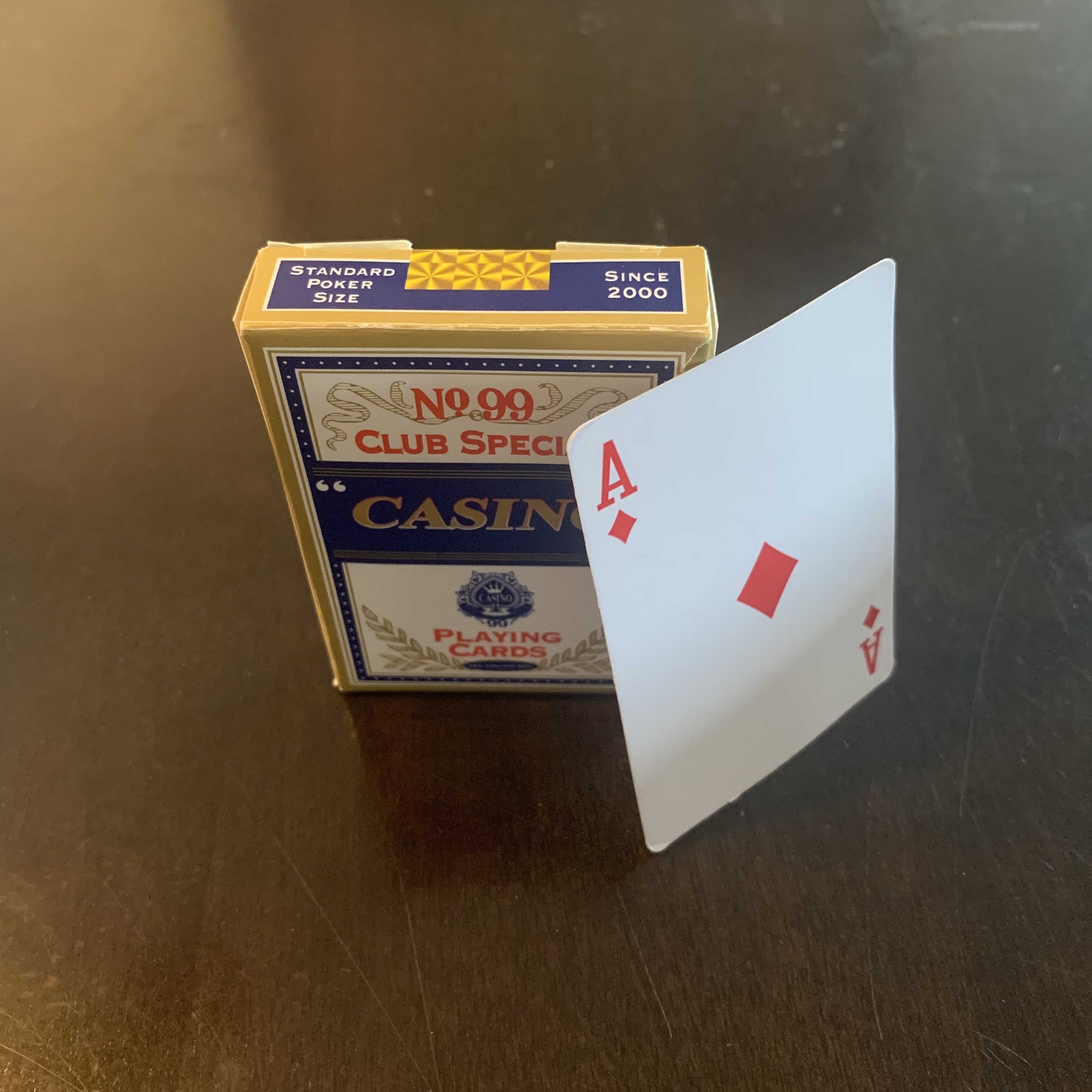 Ace of Spades next to package of playing cards.